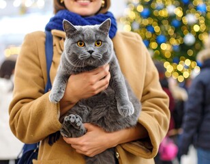 Contented cat being held by a smiling woman during a festive outdoor event