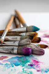 Fototapeta premium Set of paintbrushes with a splash of paint on a white background