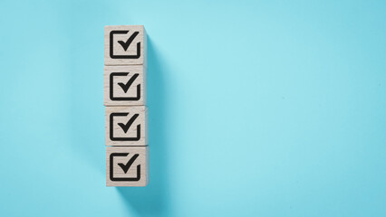 Checkmark wooden blocks on blue background. Task completion, to-do list, productivity concept. Business success, achievement, goal accomplishment, checklist