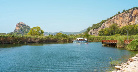 Scenic Dalyan river view with boat and rocky hills