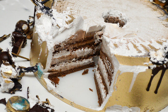 The remainder of the black and gold birthday cake after cutting showing the structure and interior of the cake.