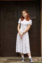 Naklejka premium Young beautiful girl in a light dress having fun outdoors on a summer day.