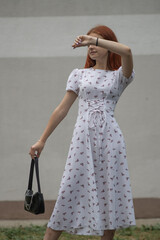 Young beautiful girl in a light dress having fun outdoors on a summer day.