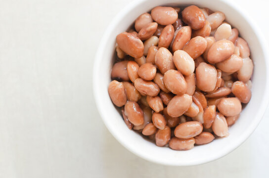 Boiled borlotti beans in a white bowl on a gray background. Italian cuisine. Vegan and vegetarian food. Selective focus. Horizontal orientation. Copy space. Top view