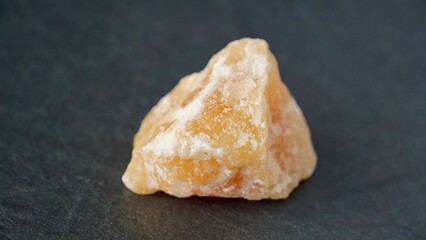 Orange calcite on dark background. Natural gemstone      