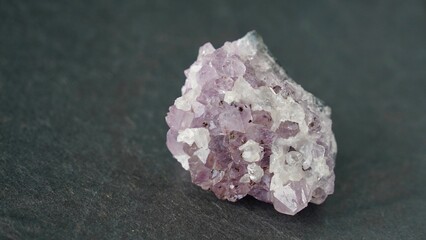 Purple amethyst gemstone on black background, closeup.
