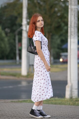 Obraz premium Young beautiful girl in a light dress having fun outdoors on a summer day.