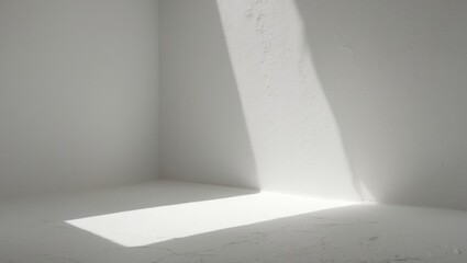 Fototapeta premium A white corner with sunlight casting a shadow on the wall and floor. Minimalist interior with natural lighting and clean lines.