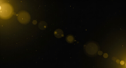 Naklejka premium Golden light leak with shimmering particles overlaying on a black background