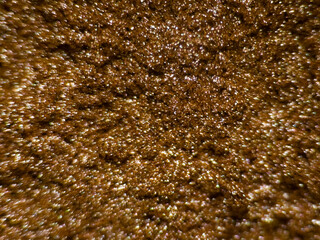 Brown glitter texture macro close-up with sparkling highlights