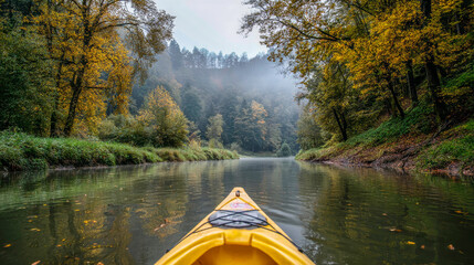 Paddling gently in a kayak, the calm river reflects the vibrant hues of autumn leaves while a soft fog envelops the forested banks, creating a serene atmosphere for exploration