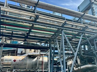 industrial steel pipes. A maze of pipes and structures in an industrial plant under a bright sky....