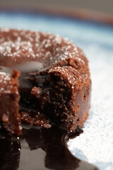 Gros plan sur un fondant au chocolat avec son cœur coulant et son chocolat liquide