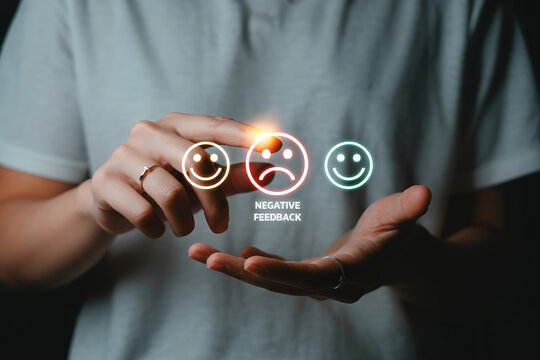 Addressing Low Feedback with Customer Satisfaction Surveys A Person's Hand Hovering Over Negative Emotion Icon for Business Review and Rating System