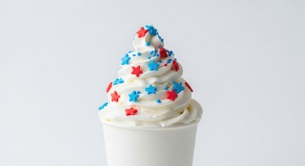Whipped Vanilla Ice Cream in a White Cup Decorated with Red and Blue Star Sprinkles on a Plain Background
