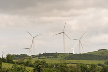 Three wind turbines are on a hillside