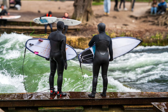 Par de surfistas preparandose para ingresar a la Eisbachwelle, en la ciudad de Munich