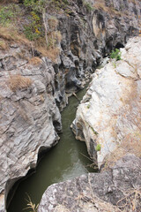 Rock Canyon Gorge with River Stream Flowing Through Natural Stone Cliffs
