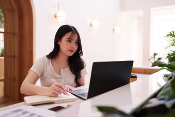 Asian adult woman freelancer remote work modern cafe environment productivity focus laptop notebook business professional