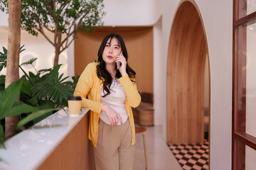 Asian adult woman professional taking business call modern cafe stylish interior design mobile...