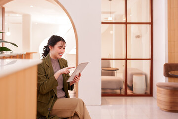 Asian adult woman works remotely business tasks using digital tablet modern cafe environment...
