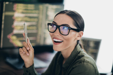 Young woman programmer smiling while working and coding at her workspace in a remote professional...
