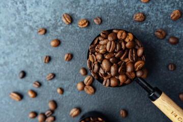 Close up of coffee beans in black measuring spoon