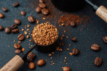 Instant coffee granules in scoop with coffee beans