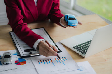 Asian businesswoman in suit smiling while advising clients on insurance policies, trusts, finances...