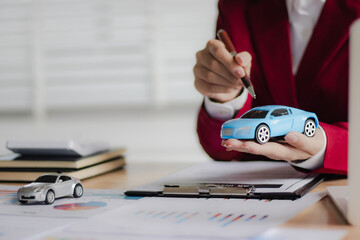 Asian businesswoman in suit smiling while advising clients on insurance policies, trusts, finances...