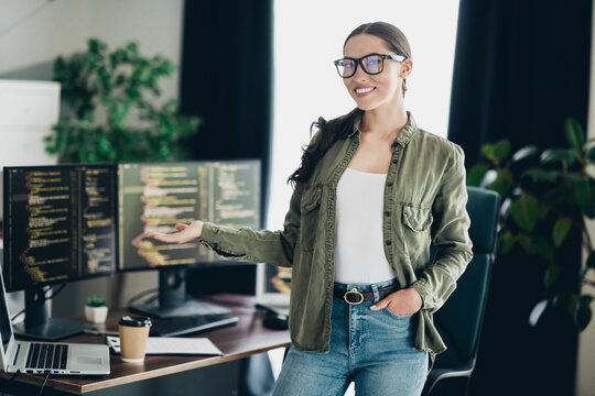 Young professional programmer woman presenting coding progress in stylish home office with multiple monitor setup