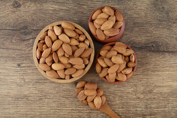 Fresh almonds in wooden bowl and earthen pots