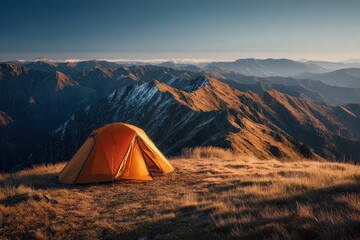 Orange tent on grassy mountain ridge with stunning mountain views. Perfect for adventure, outdoors, travel, and escape from the everyday.