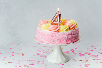 Celebration of a child's fourth birthday with a colorful cake and confetti