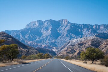 Fototapeta premium Wide road stretches through stunning mountainous landscape under