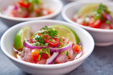 Fresh ceviche appetizer with lime and cilantro in white bowls