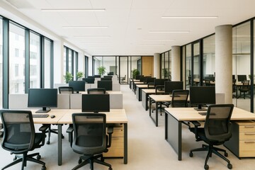 Modern open-plan office interior with rows of workstations, ergonomic chairs, and large windows providing natural light and a clean professional look.
