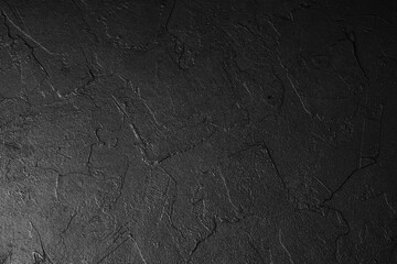 Black textured background surface with cracked pattern