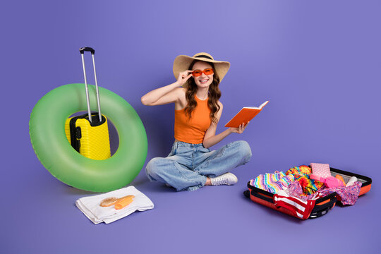 Cheerful girl ready for a summer vacation with stylish accessories, luggage, and a vibrant purple background. - Powered by Adobe