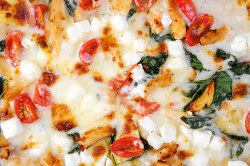 Closeup of pizza with melted cheese, tomatoes and spinach for fast food, menu or tasty lunch concept