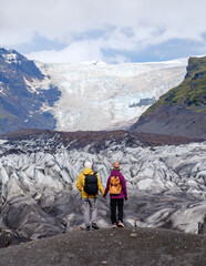 Hikers marvel at the breathtaking Svinafellsjokull Glacier in Iceland. Towering ice formations and...