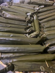 Lontong is a traditional Indonesian dish made from rice that is boiled and compressed in banana leaves, then cut into small cylindrical or round pieces. The texture is firm yet soft, and it has a mild