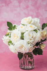 Closeup of white roses in bouquet against pink background