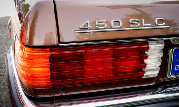 Detailansicht einer Heckleuchte und des Typenschilds eines braunen Mercedes-Benz 450 SLC