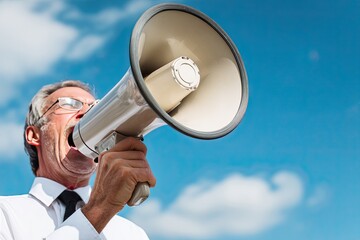 Man shouting into a megaphone against a clear blue sky (1)