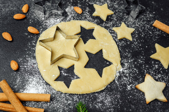 Christmas star cookies baking with flour and ingredients on dark table for food blog and seasonal recipe concept