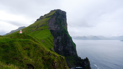 Dramatic cliffs rise majestically above the tranquil waters of the North Atlantic Ocean in the...