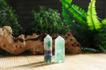 Aura. Beautiful crystals, driftwood and green plants on wooden surface