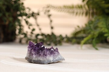 Aura. Beautiful amethyst on beige fabric indoors
