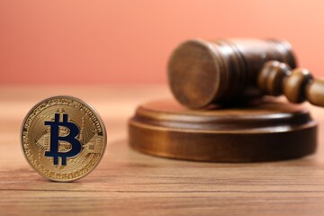 Cryptocurrency. Bitcoin and judge's gavel on wooden table, closeup